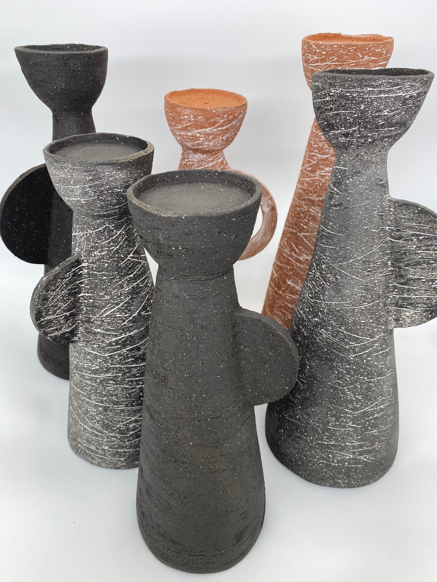 A collection of black and terracotta ceramic vessels