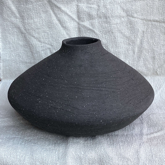 Black, wide belly ceramic decor vessel with stone texture.