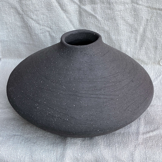 Black, wide belly ceramic decor vessel with stone texture.