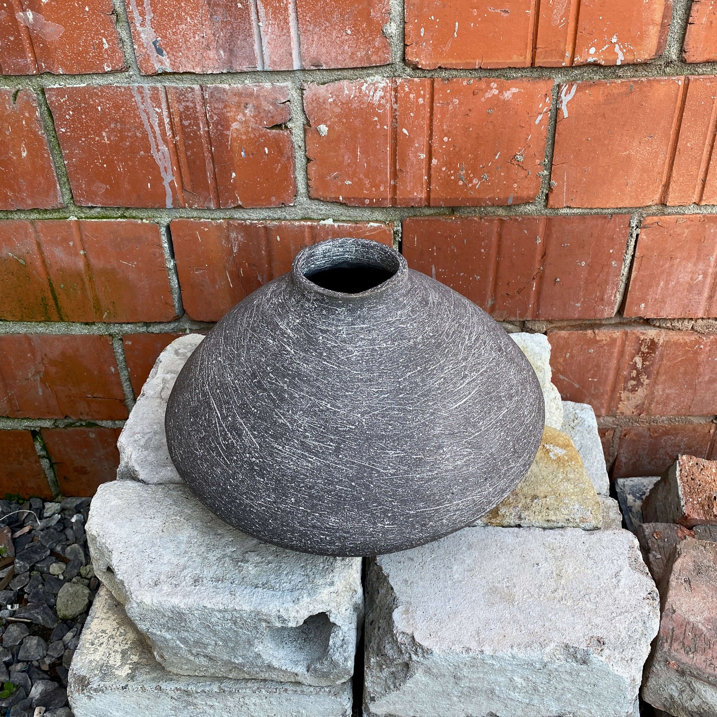 Black, wide belly ceramic decor vessel with white texture.